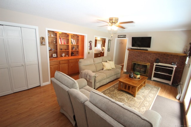 46 Ryan Rd, Tolland, CT 06084 - living area with light wood finished floors, a ceiling fan, and a fireplace