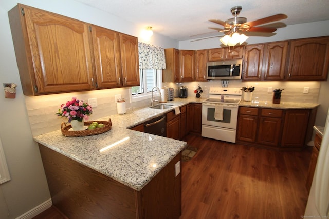 46 Ryan Rd, Tolland, CT 06084 - kitchen featuring appliances with stainless steel finishes, light stone counters, tasteful backsplash, dark wood-style floors, and a peninsula
