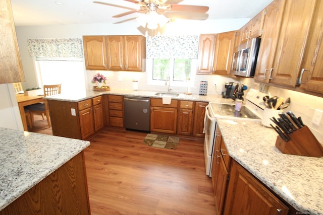46 Ryan Rd, Tolland, CT 06084 - kitchen with stainless steel appliances, light stone countertops, a peninsula, a ceiling fan, and light wood-type flooring
