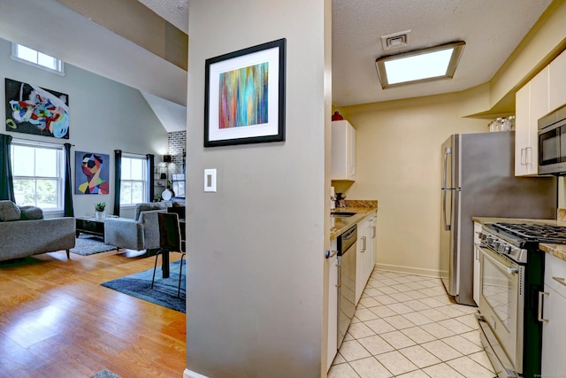 685 Quinnipiac Ave Unit 685, New Haven, CT 06513 - kitchen featuring appliances with stainless steel finishes, white cabinets, light countertops, open floor plan, and a high ceiling