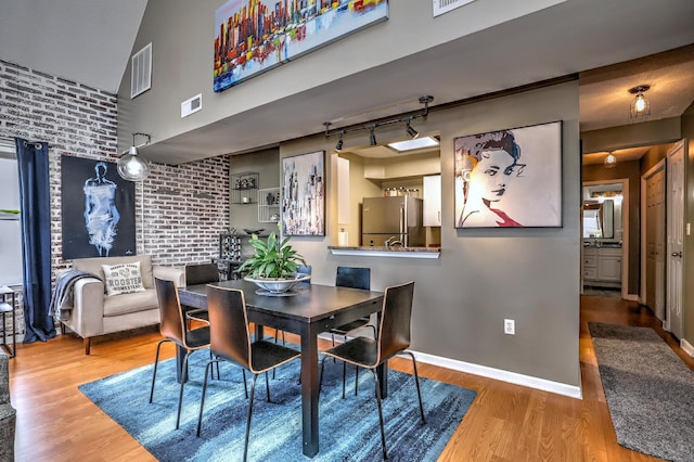 685 Quinnipiac Ave Unit 685, New Haven, CT 06513 - dining area with wood finished floors, brick wall, and rail lighting
