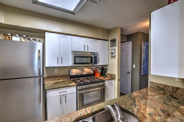 685 Quinnipiac Ave Unit 685, New Haven, CT 06513 - kitchen featuring appliances with stainless steel finishes, white cabinets, dark stone counters, and a textured ceiling