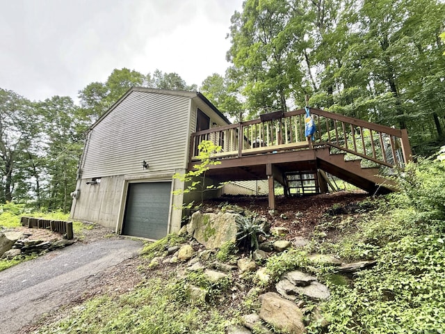 21 Pigeon Swamp Rd, Lebanon, CT 06249 - view of property exterior with an attached garage, stairs, a wooden deck, and asphalt driveway
