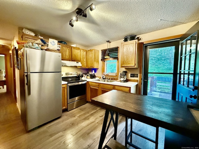 21 Pigeon Swamp Rd, Lebanon, CT 06249 - kitchen with stainless steel appliances, under cabinet range hood, a textured ceiling, light wood-style floors, and light countertops