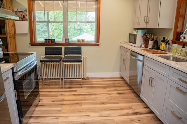 65 Willard St, Hamden, CT 06518 - kitchen with appliances with stainless steel finishes, under cabinet range hood, light wood-style flooring, and light stone countertops