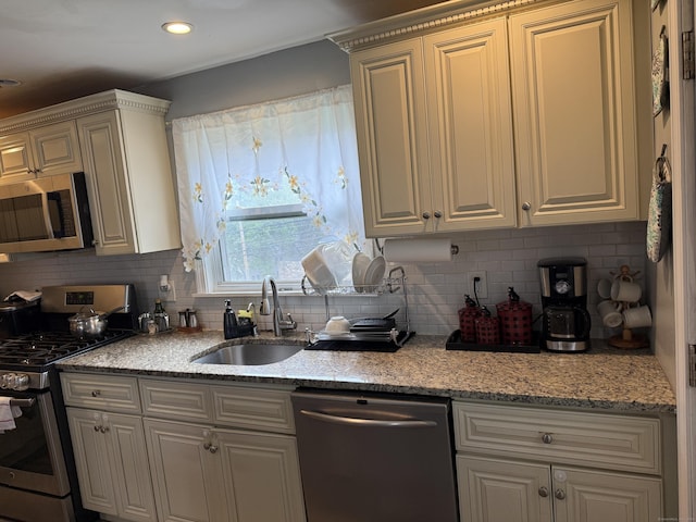 15 Edwards St, Bridgeport, CT 06606 - kitchen with stainless steel appliances, backsplash, light stone counters, recessed lighting, and cream cabinetry