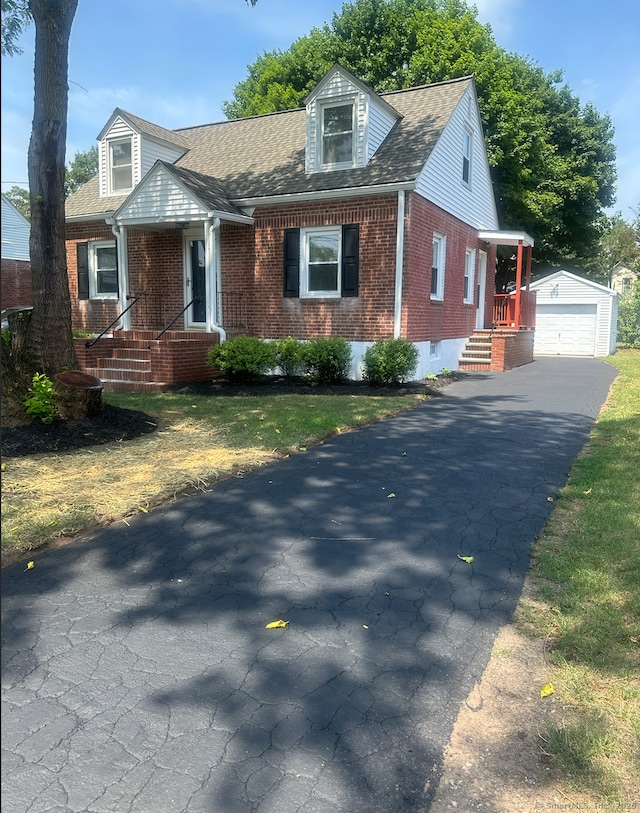 63 Barraclough Ave, Hamden, CT 06517 - cape cod house with brick siding, an outdoor structure, a detached garage, and a shingled roof