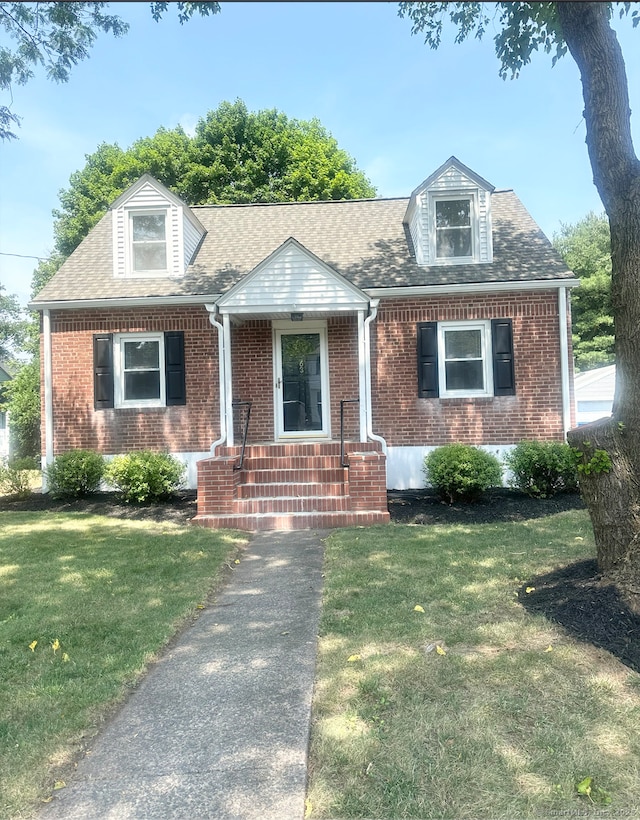 63 Barraclough Ave, Hamden, CT 06517 - cape cod home with brick siding, a front lawn, and roof with shingles