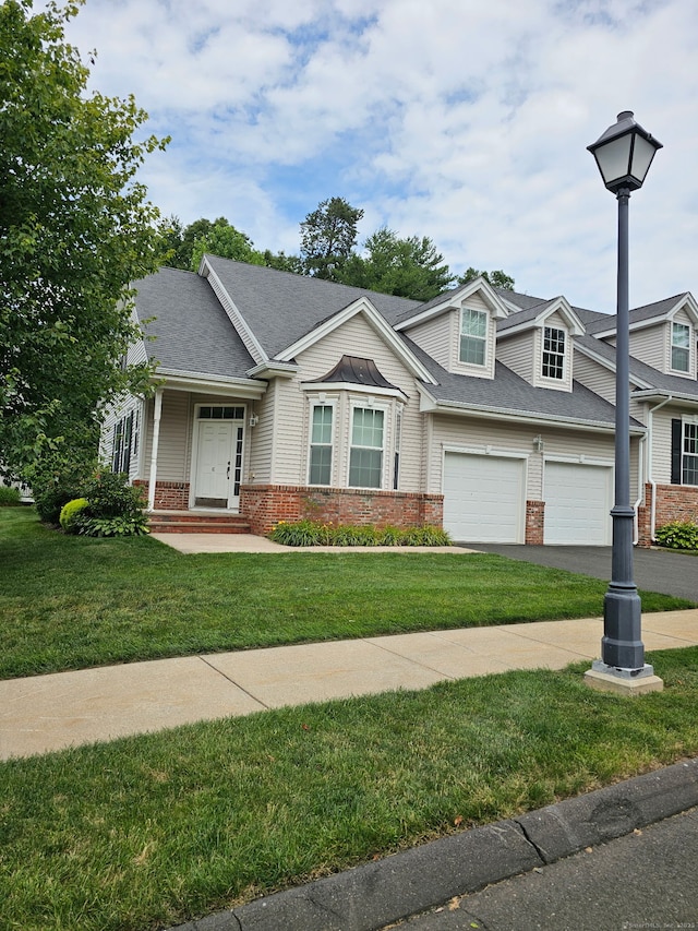 6 Haskins Rd Unit 6, Windsor, CT 06095 - view of front facade featuring brick siding, a garage, asphalt driveway, and a front lawn