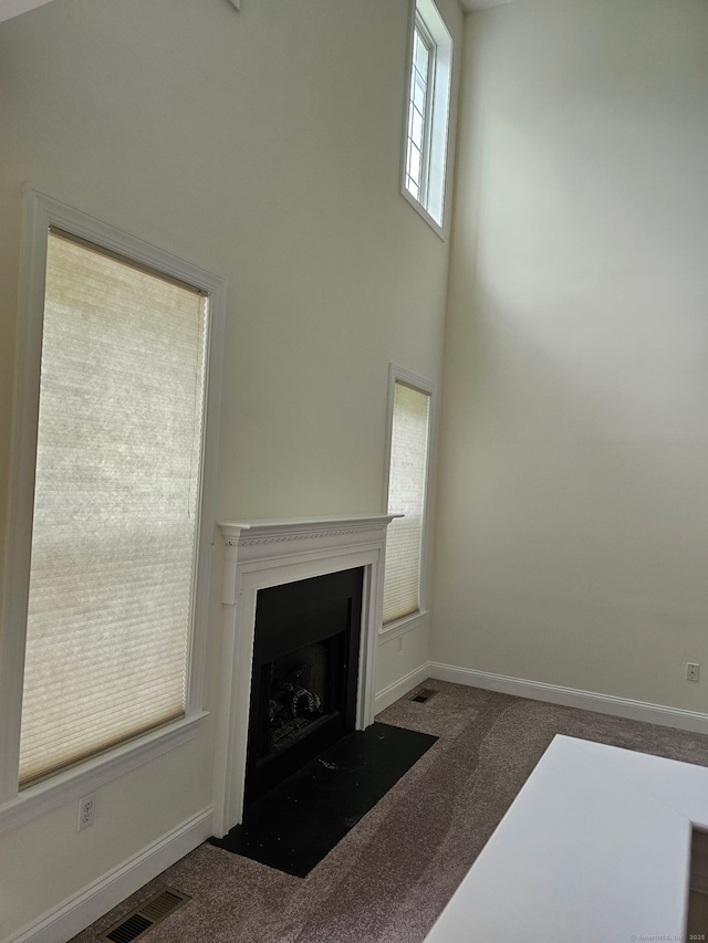 6 Haskins Rd Unit 6, Windsor, CT 06095 - unfurnished living room featuring carpet flooring, a towering ceiling, and a fireplace with flush hearth