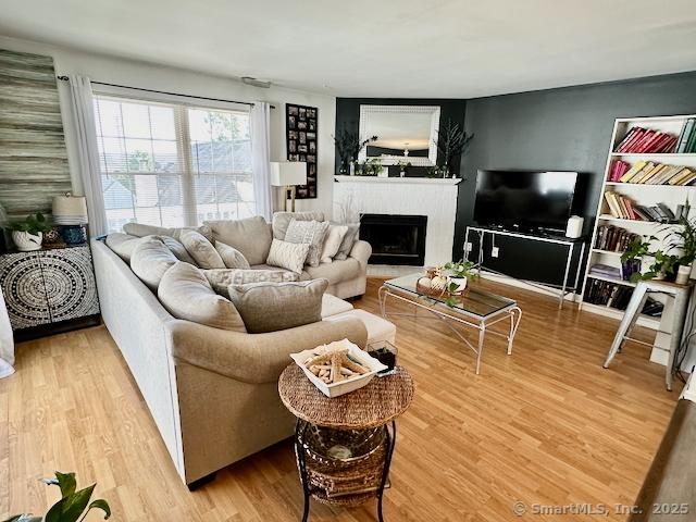 2390 State St Apt 7J, Hamden, CT 06517 - living room featuring a fireplace with raised hearth and wood finished floors