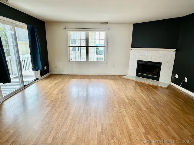 2390 State St Apt 7J, Hamden, CT 06517 - unfurnished living room featuring light wood-style flooring and a fireplace