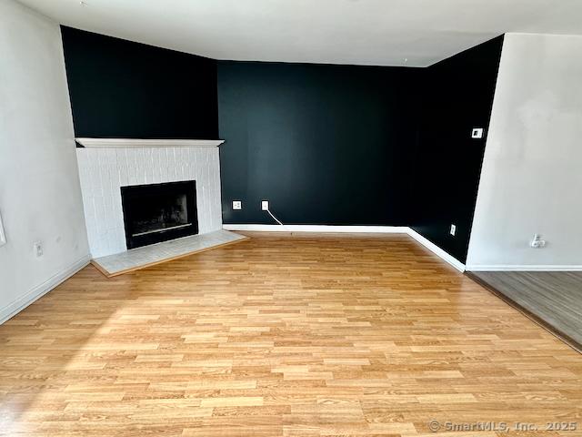 2390 State St Apt 7J, Hamden, CT 06517 - unfurnished living room featuring a fireplace and light wood-style floors