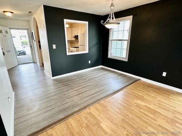 2390 State St Apt 7J, Hamden, CT 06517 - unfurnished room featuring wood finished floors, arched walkways, and healthy amount of natural light