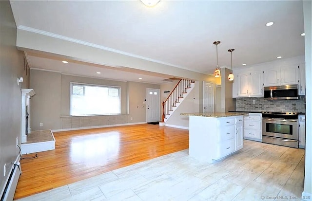 40 Mark St, Bristol, CT 06010 - kitchen with appliances with stainless steel finishes, white cabinets, ornamental molding, backsplash, and a baseboard radiator