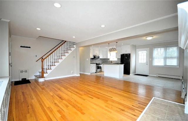 40 Mark St, Bristol, CT 06010 - unfurnished living room featuring a baseboard radiator, light wood finished floors, ornamental molding, stairs, and recessed lighting