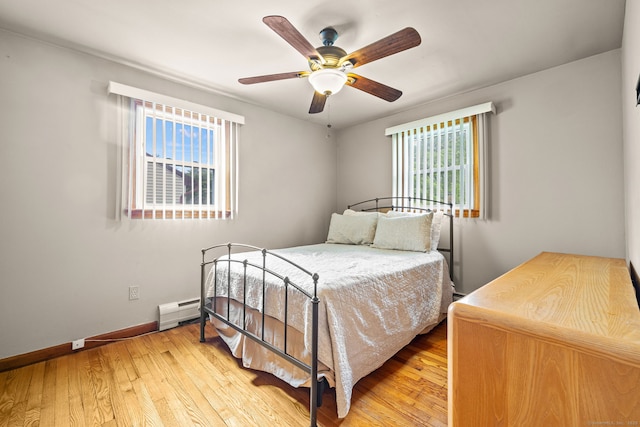 128 Auburn St, Stratford, CT 06614 - bedroom with multiple windows, light wood-style flooring, a baseboard heating unit, and ceiling fan
