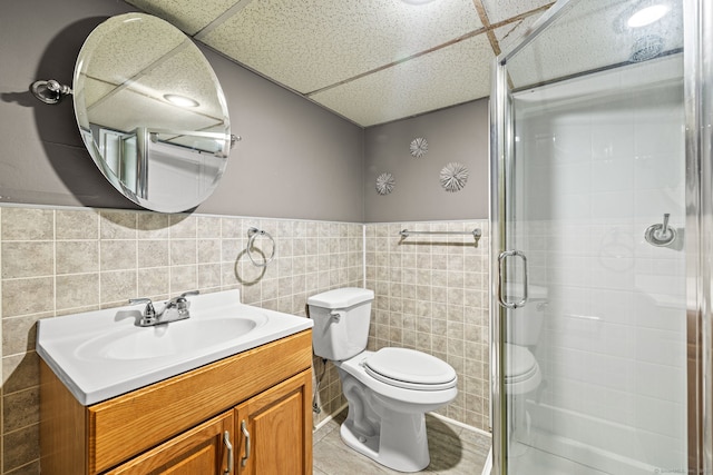 128 Auburn St, Stratford, CT 06614 - bathroom with vanity, a stall shower, tile walls, a wainscoted wall, and a paneled ceiling