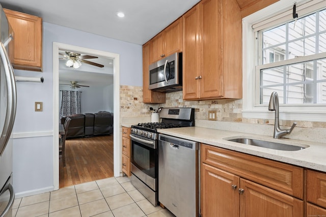 35 Oberlin Rd, Hamden, CT 06514 - kitchen featuring stainless steel appliances, a ceiling fan, light tile patterned floors, backsplash, and light stone counters