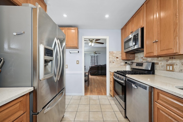35 Oberlin Rd, Hamden, CT 06514 - kitchen featuring stainless steel appliances, ceiling fan, light tile patterned floors, decorative backsplash, and light stone countertops
