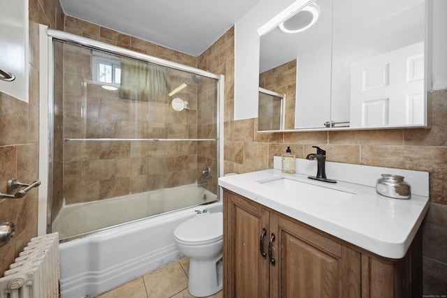 35 Oberlin Rd, Hamden, CT 06514 - bathroom featuring radiator, tile walls, vanity, enclosed tub / shower combo, and tile patterned floors