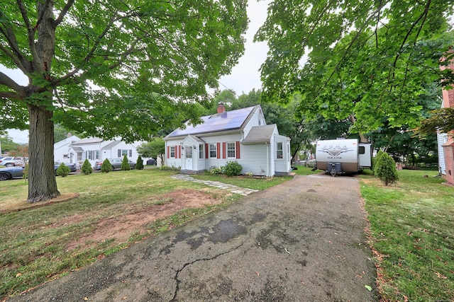 35 Oberlin Rd, Hamden, CT 06514 - bungalow with driveway, a chimney, a front yard, and roof mounted solar panels
