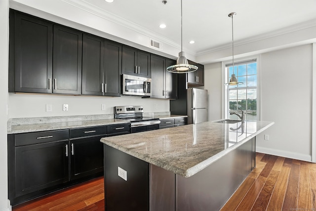 142 E Ave Unit A302, Norwalk, CT 06851 - kitchen featuring appliances with stainless steel finishes, dark cabinetry, a kitchen island with sink, ornamental molding, and dark wood-style flooring