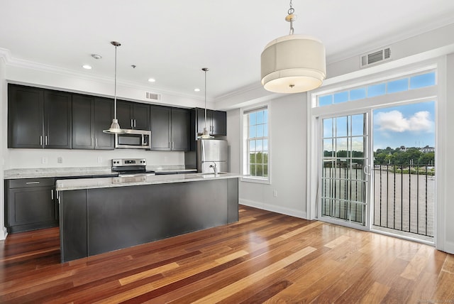 142 E Ave Unit A302, Norwalk, CT 06851 - kitchen with appliances with stainless steel finishes, wood finished floors, an island with sink, crown molding, and hanging light fixtures