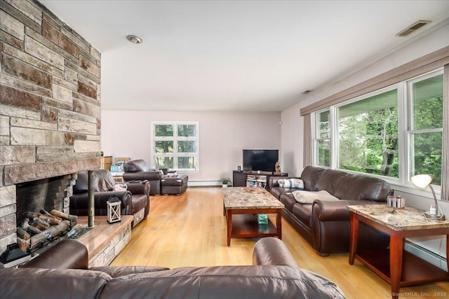 129 Russell Ave, Orange, CT 06477 - living area featuring wood finished floors, a baseboard radiator, and a stone fireplace