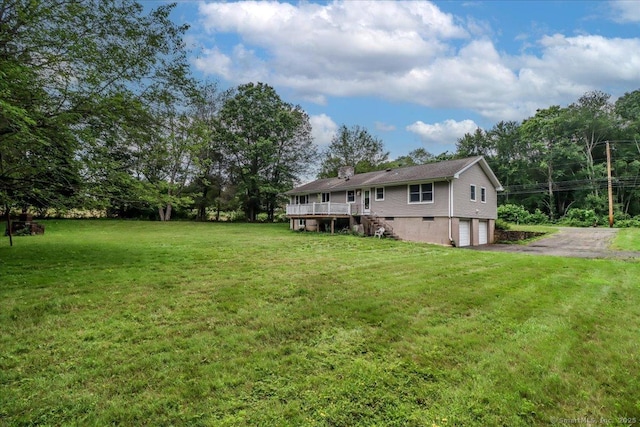 129 Russell Ave, Orange, CT 06477 - view of grassy yard featuring a garage, driveway, a wooden deck, and stairway