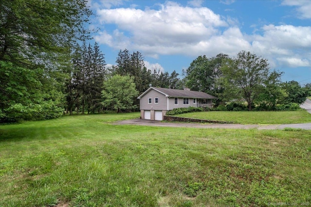 129 Russell Ave, Orange, CT 06477 - view of front of property with a garage, a chimney, a front lawn, and driveway