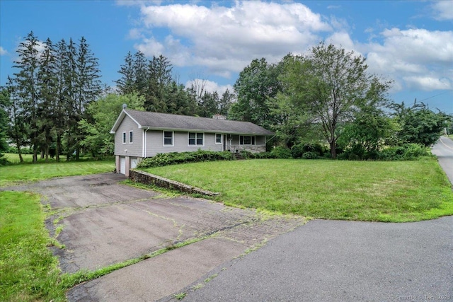 129 Russell Ave, Orange, CT 06477 - single story home with an attached garage, asphalt driveway, a chimney, a front yard, and view of wooded area