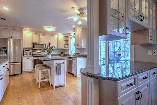 662 Booth Hill Rd, Trumbull, CT 06611 - kitchen featuring appliances with stainless steel finishes, ceiling fan, open shelves, light wood-style flooring, and a breakfast bar