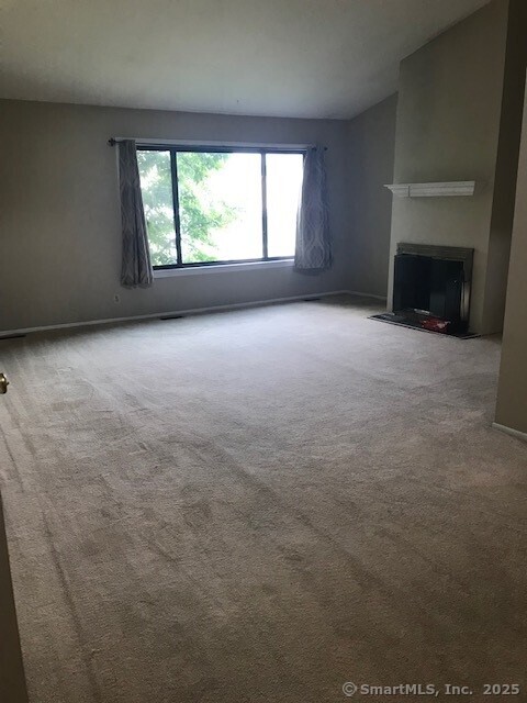 75 Lawson Ln Unit 75, Ridgefield, CT 06877 - unfurnished living room featuring carpet and a fireplace with flush hearth