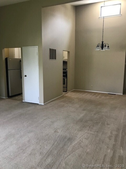 75 Lawson Ln Unit 75, Ridgefield, CT 06877 - empty room with a towering ceiling, carpet, and a chandelier