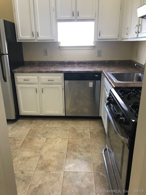 75 Lawson Ln Unit 75, Ridgefield, CT 06877 - kitchen featuring appliances with stainless steel finishes, white cabinetry, dark countertops, and light stone finish floors