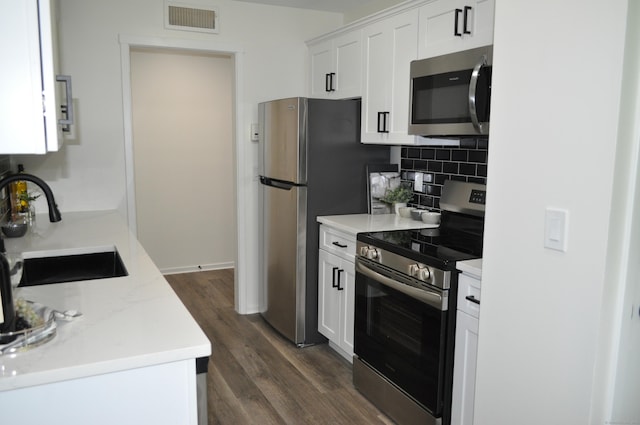 25 Heritage Dr Unit 25, Avon, CT 06001 - kitchen with appliances with stainless steel finishes, dark wood-type flooring, backsplash, light countertops, and white cabinetry