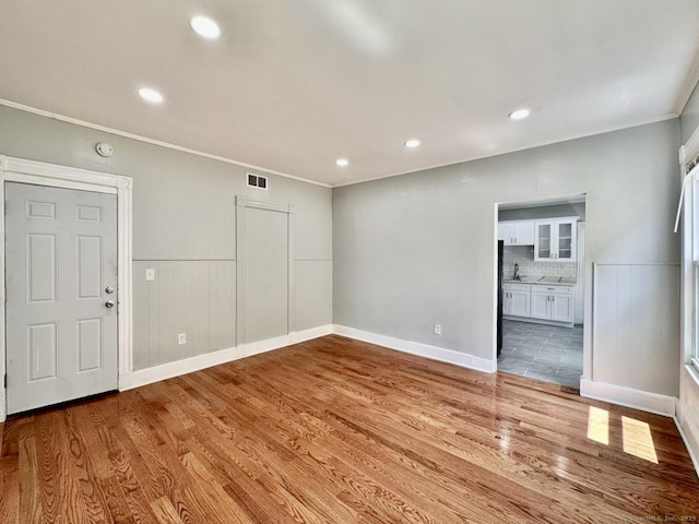 57 Houston St, New Haven, CT 06513 - unfurnished living room with wood finished floors, ornamental molding, wainscoting, and recessed lighting