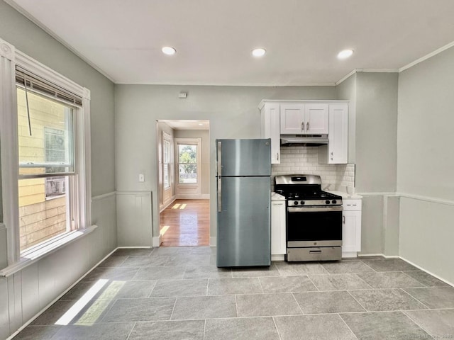 57 Houston St, New Haven, CT 06513 - kitchen with stainless steel appliances, under cabinet range hood, white cabinets, ornamental molding, and tasteful backsplash