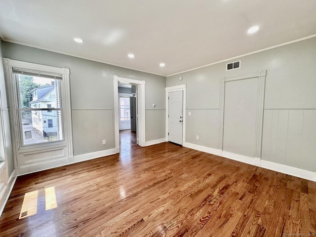 57 Houston St, New Haven, CT 06513 - empty room featuring wood finished floors, a wainscoted wall, ornamental molding, a decorative wall, and recessed lighting
