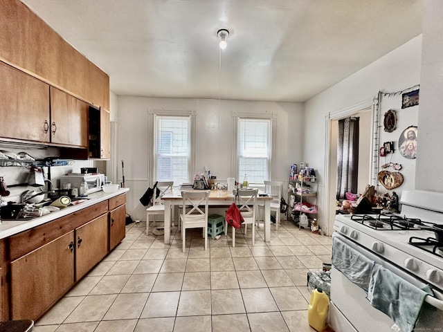 57 Houston St, New Haven, CT 06513 - kitchen featuring white appliances, light countertops, light tile patterned floors, and brown cabinetry