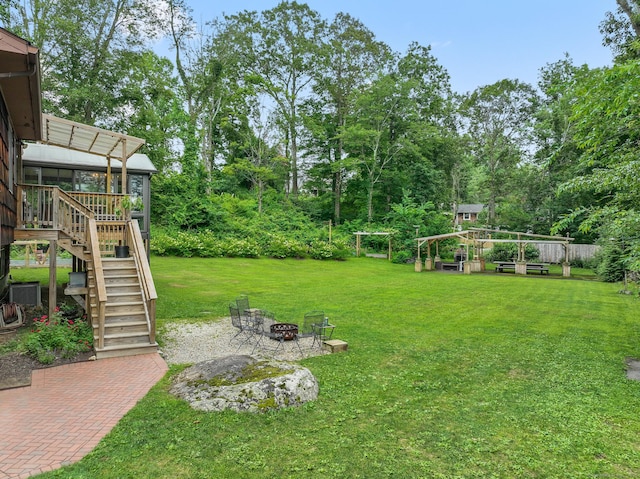 16 Pond Crest Rd, Danbury, CT 06811 - view of green lawn with stairs, a fire pit, a sunroom, view of wooded area, and a patio area