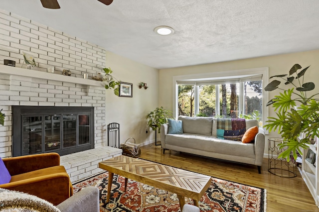 420 Newcomb Rd, North Kingston, Rhode Island, RI 02852 - living room featuring a textured ceiling, wood finished floors, a fireplace, and ceiling fan
