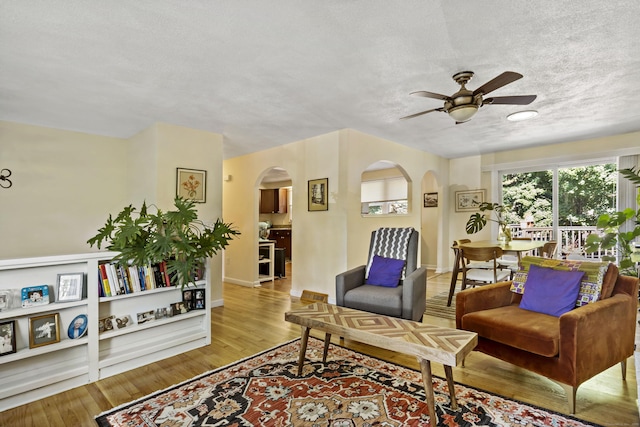 420 Newcomb Rd, North Kingston, Rhode Island, RI 02852 - living room featuring arched walkways, a ceiling fan, a textured ceiling, and light wood-type flooring