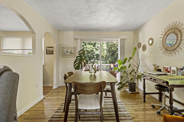 420 Newcomb Rd, North Kingston, Rhode Island, RI 02852 - dining room featuring wood finished floors, arched walkways, and a textured ceiling