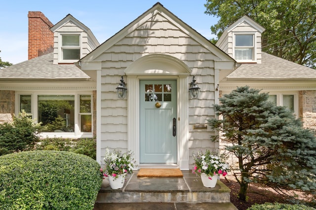 33 Ridgeley St, Darien, CT 06820 - view of exterior entry featuring a shingled roof and a chimney