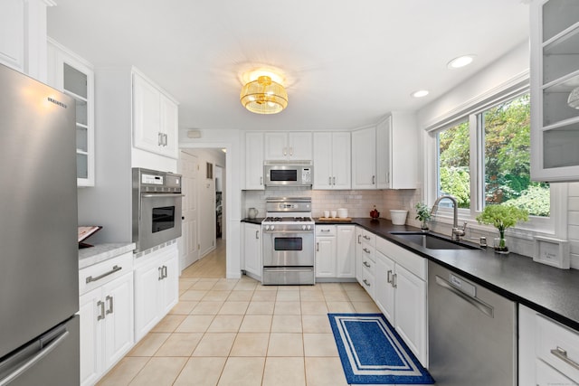 33 Ridgeley St, Darien, CT 06820 - kitchen featuring appliances with stainless steel finishes, light tile patterned floors, backsplash, dark countertops, and recessed lighting