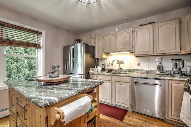 68 Benjamin Rd, East Haven, CT 06513 - kitchen with stainless steel appliances, light stone counters, light wood-style floors, a center island, and tasteful backsplash