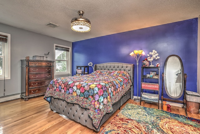 68 Benjamin Rd, East Haven, CT 06513 - bedroom with wood finished floors, a textured ceiling, and a baseboard radiator