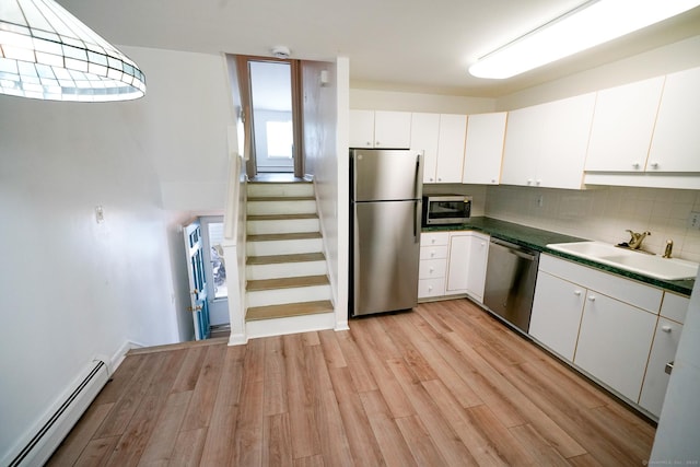 50 E Hill Rd Apt 2H, Canton, CT 06019 - kitchen with stainless steel appliances, a baseboard radiator, light wood-style floors, tasteful backsplash, and white cabinets